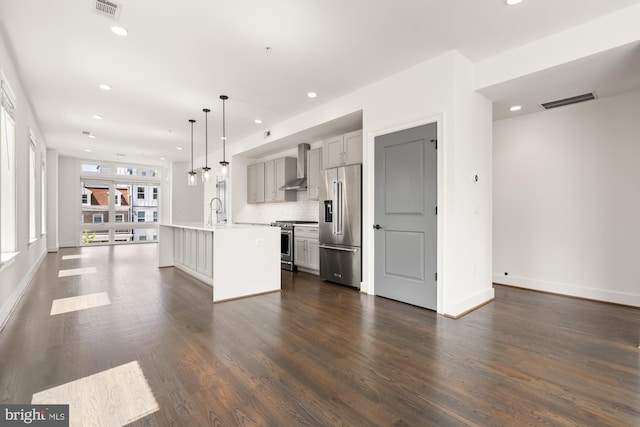 kitchen featuring appliances with stainless steel finishes, wall chimney exhaust hood, recessed lighting, gray cabinetry, and visible vents