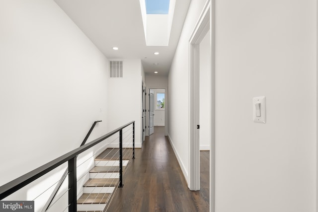 corridor with visible vents, dark wood-style flooring, baseboards, recessed lighting, and a skylight