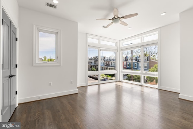empty room with dark wood finished floors, a ceiling fan, baseboards, recessed lighting, and visible vents