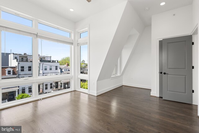 additional living space with recessed lighting, baseboards, and dark wood-type flooring