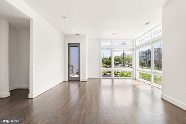 empty room with baseboards, recessed lighting, and dark wood-style floors