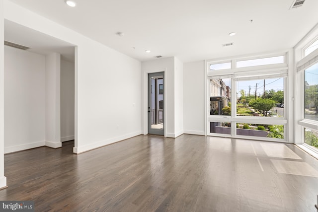 unfurnished room featuring recessed lighting, visible vents, a healthy amount of sunlight, and dark wood-type flooring