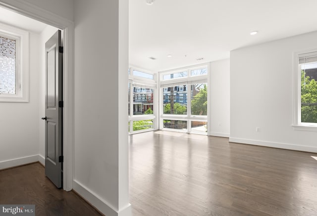 corridor with baseboards, recessed lighting, and wood finished floors