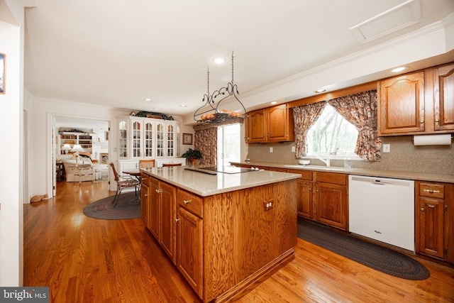 kitchen featuring black electric stovetop, dishwasher, wood finished floors, and a kitchen island