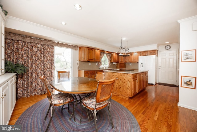 dining area with light wood-type flooring, recessed lighting, and ornamental molding