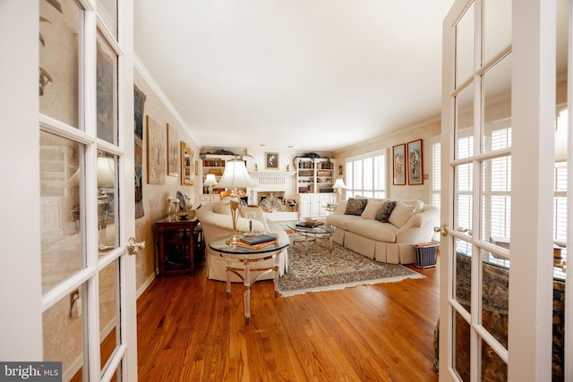 living room with ornamental molding, french doors, and wood finished floors