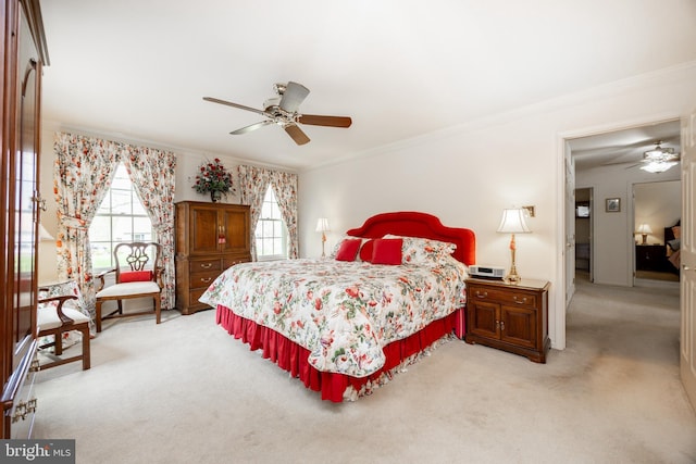 bedroom with a ceiling fan, ornamental molding, and light colored carpet