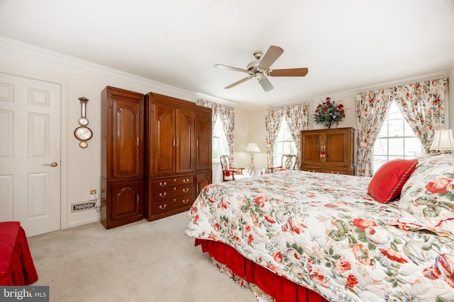 bedroom featuring light colored carpet, ornamental molding, and multiple windows