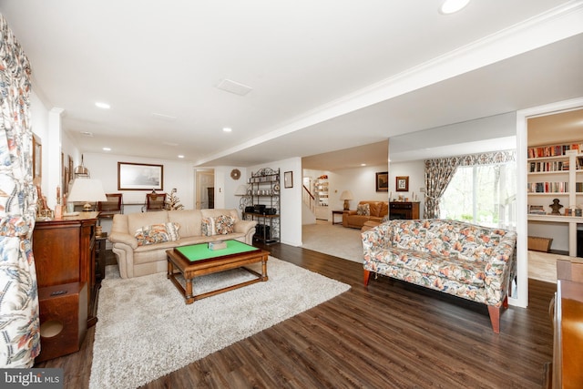 living room with recessed lighting, wood finished floors, crown molding, and stairway
