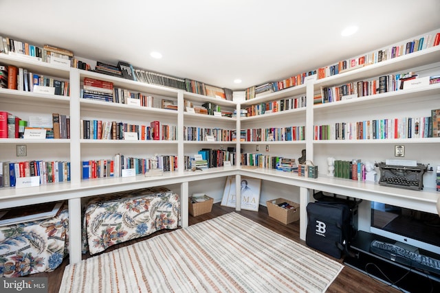 sitting room featuring recessed lighting, wood finished floors, and bookshelves