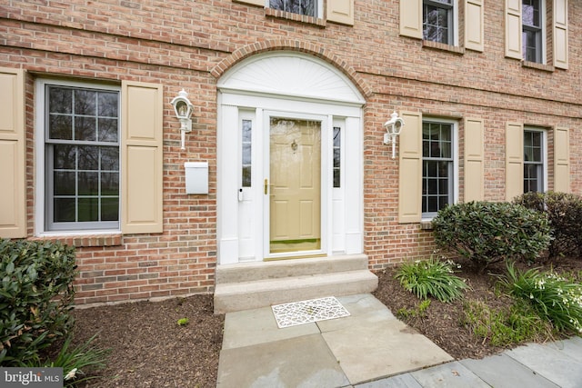 property entrance featuring brick siding