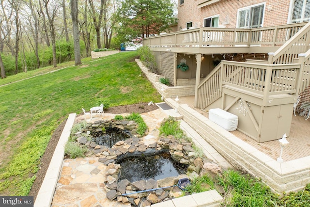 view of yard featuring a small pond, stairway, and a deck
