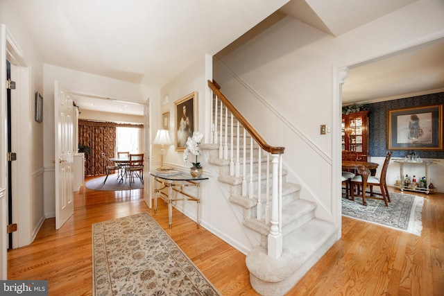 staircase featuring wallpapered walls and wood finished floors