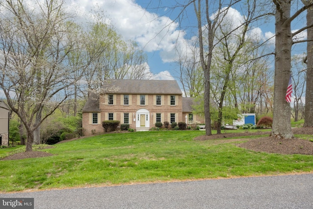 colonial inspired home featuring a front lawn