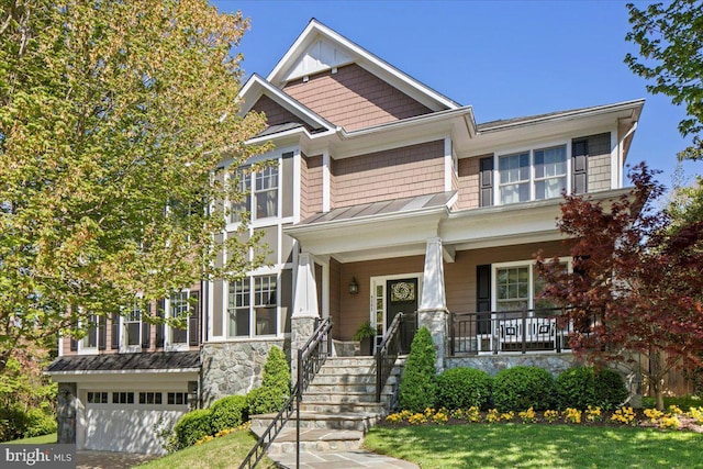 craftsman-style house featuring a standing seam roof, stone siding, a porch, metal roof, and an attached garage