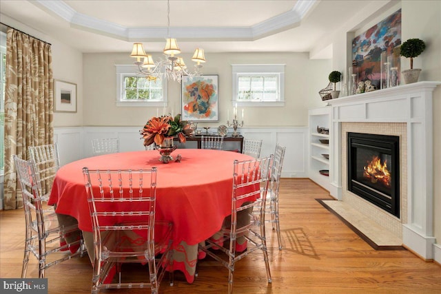dining room with wood finished floors, crown molding, a chandelier, and a tray ceiling