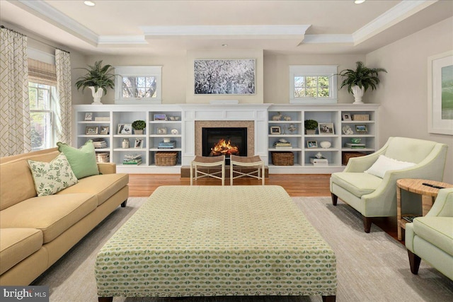 interior space with a wealth of natural light, ornamental molding, wood finished floors, and a tray ceiling