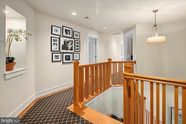 hall featuring baseboards, an upstairs landing, visible vents, and recessed lighting