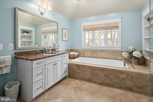 full bathroom featuring a garden tub, lofted ceiling, and vanity