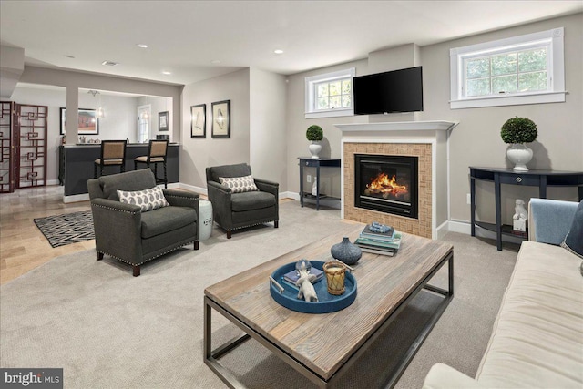 living area with recessed lighting, baseboards, light carpet, and a fireplace