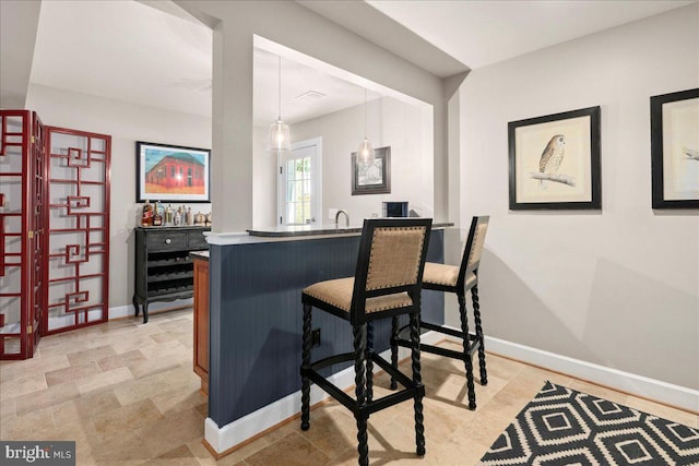 bar featuring pendant lighting and baseboards