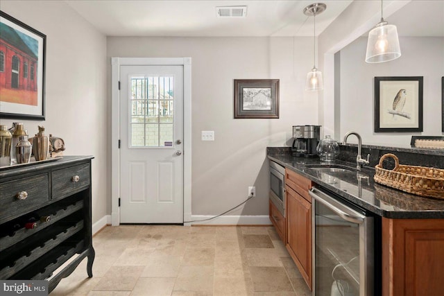 bar with wine cooler, a sink, baseboards, visible vents, and indoor wet bar