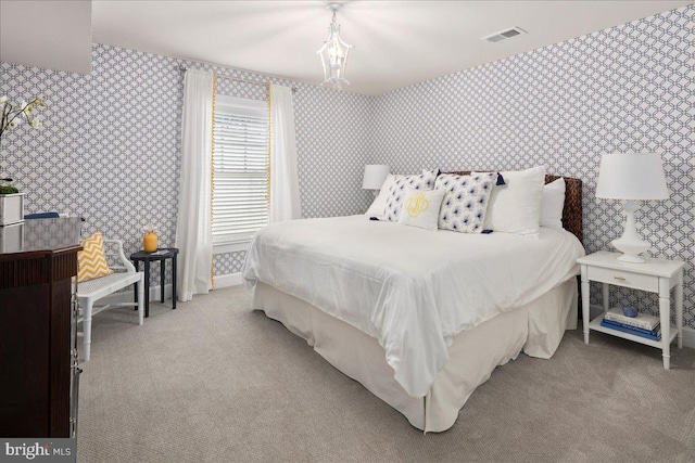 bedroom with wallpapered walls, visible vents, and light colored carpet