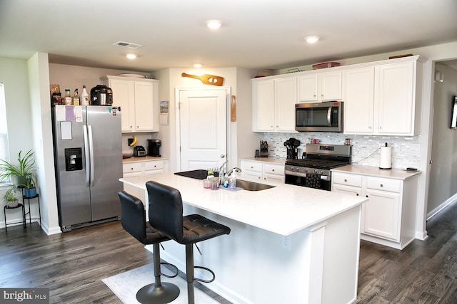 185 Petal Dr, Pottstown, PA 19464 - kitchen featuring dark wood finished floors, an island with sink, stainless steel appliances, visible vents, and white cabinetry