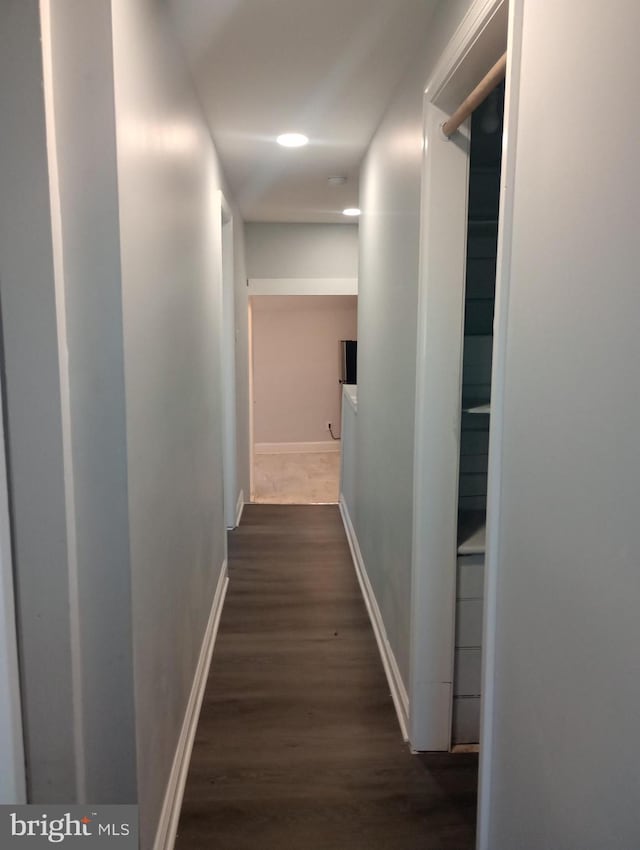 corridor with baseboards and dark wood-style floors