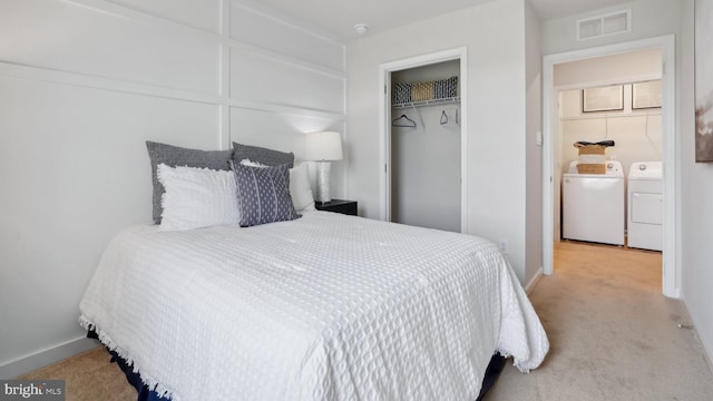 bedroom featuring washing machine and clothes dryer, light carpet, baseboards, visible vents, and a closet