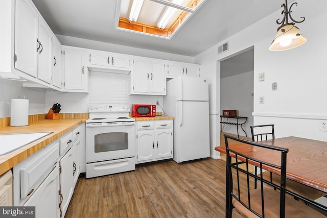 kitchen with white cabinets, visible vents, dark wood-type flooring, and white appliances