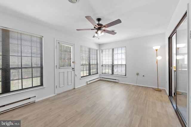 unfurnished living room featuring a baseboard heating unit, light wood-style floors, baseboards, and ceiling fan