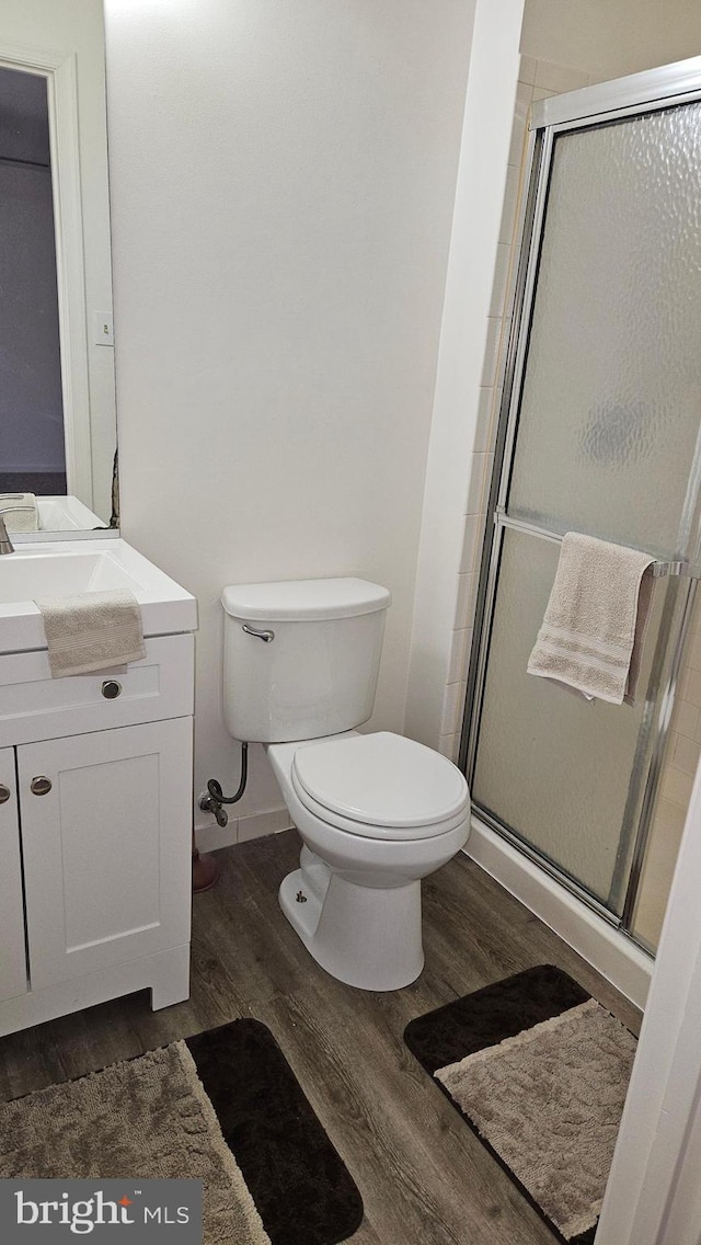 1105 Castle Harbour Way Unit 2B, Glen Burnie, MD 21060 - bathroom featuring toilet, a stall shower, baseboards, wood finished floors, and vanity