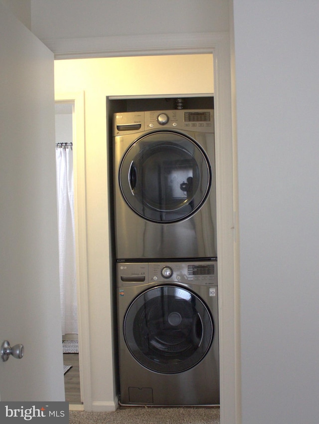 1105 Castle Harbour Way Unit 2B, Glen Burnie, MD 21060 - laundry room featuring stacked washer and dryer, baseboards, carpet floors, and laundry area