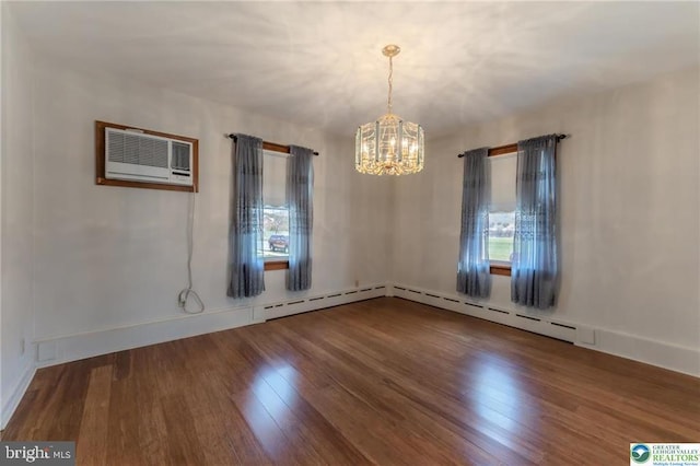 unfurnished room featuring an inviting chandelier, baseboards, wood finished floors, and a wealth of natural light