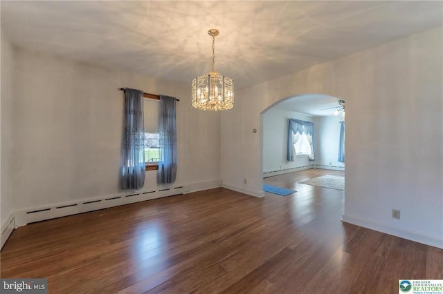 empty room featuring arched walkways, baseboard heating, wood finished floors, baseboards, and a chandelier