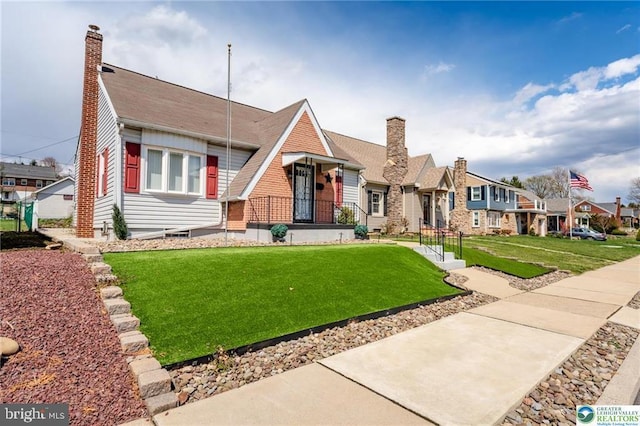 view of front of house featuring a chimney, a front yard, and a residential view