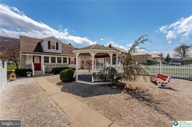view of front facade featuring a porch, a gazebo, and fence