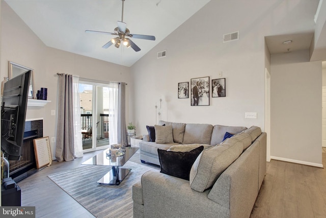 living room with high vaulted ceiling, ceiling fan, wood finished floors, and visible vents