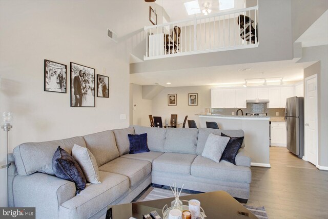 living area with light wood-style floors and a high ceiling