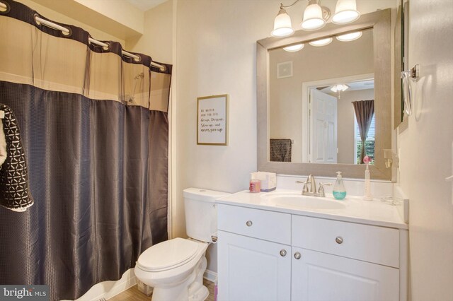 full bath with vanity, a shower with curtain, toilet, and visible vents