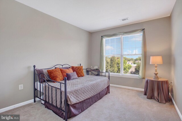 carpeted bedroom with baseboards, multiple windows, and visible vents
