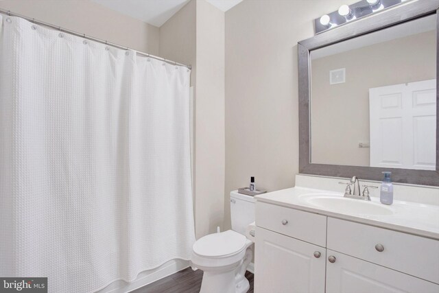 full bathroom featuring toilet, wood finished floors, and vanity