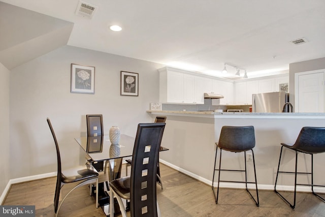 dining area with recessed lighting, baseboards, light wood finished floors, and visible vents