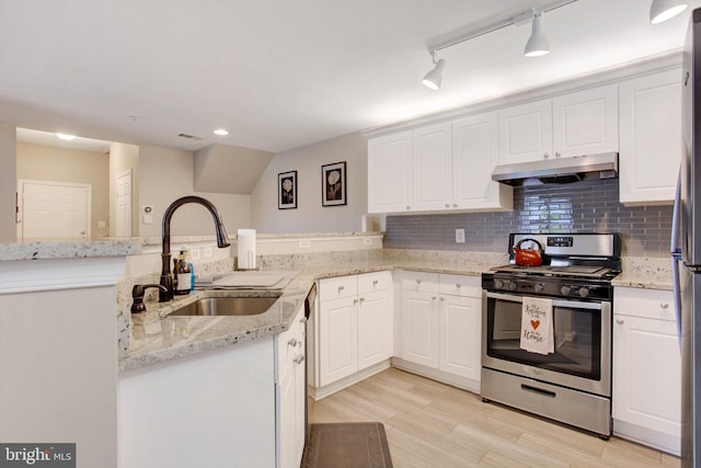kitchen with stainless steel gas range, a sink, light wood finished floors, a peninsula, and under cabinet range hood