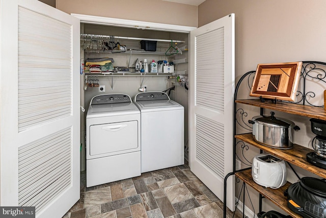 laundry area featuring separate washer and dryer, laundry area, and stone finish flooring