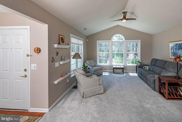 carpeted living area with ceiling fan, baseboards, and lofted ceiling