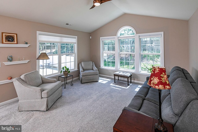 carpeted living room with baseboards, visible vents, a ceiling fan, and lofted ceiling