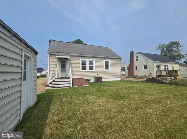8464 Geneva Rd, Pasadena, MD 21122 - rear view of house with a lawn, central AC, and a shingled roof