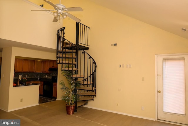 stairway with ceiling fan, high vaulted ceiling, baseboards, and wood finished floors